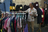 An Iranian vendor adjusts clothes on a sidewalk in downtown Tehran, Iran, Monday, July 30, 2018. Iran's currency plummeted to a record low Monday, a week before the United States restores sanctions lifted under the unraveling nuclear deal, giving rise to fears of prolonged economic suffering and further civil unrest. (AP Photo/Vahid Salemi)