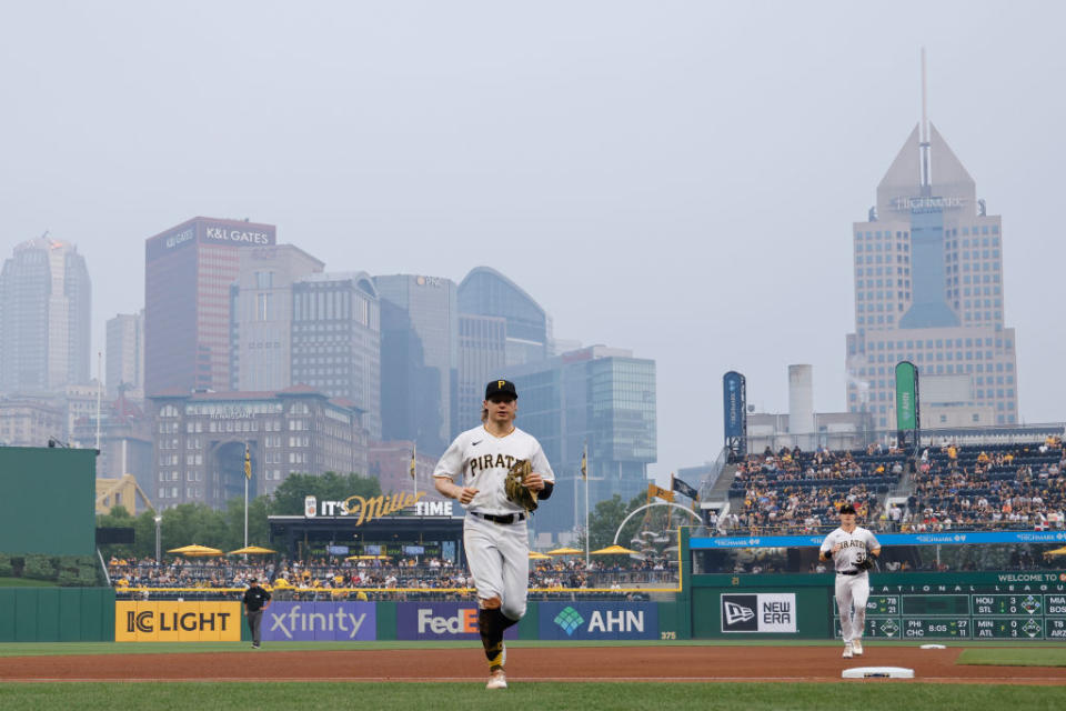Pittsburgh Pirates center fielder Jack Suwinski (65) and right fielder Henry Davis (32) jog off the field in between innings as wildfire smoke from wildfires in Central Canada descends on the downtown skyline