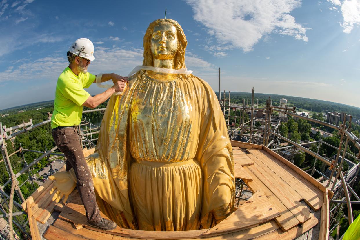 Bryon Roesselet from Conrad Schmitt gilds the Statue of Mary atop the Golden Dome on the University of Notre Dame's Main Building in July.