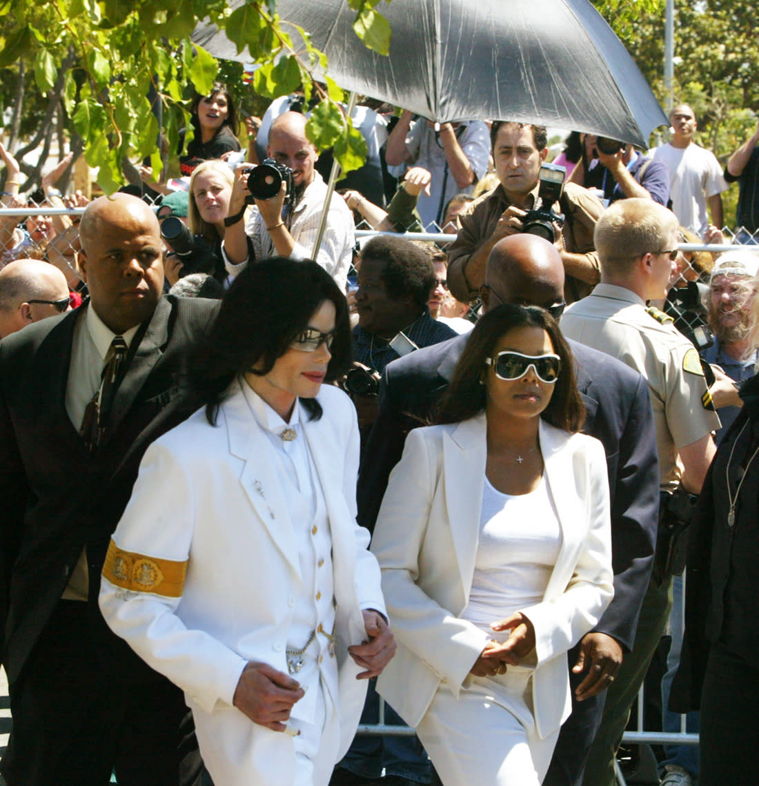 Singer Michael Jackson (L) and sister Janet Jackson walk back to courthouse after greeting fans during a lunch break at a pretrial hearing in Santa Maria, California August 16, 2004. Santa Barbara county district attorney Thomas Sneddon has been subpoenaed by Jackson's lawyers to testify during the pretrial hearing on the probe of Bradley Miller, a private investigator with ties to Jackson, whose office was searched by law enforcement officers in November 2003.  (Photo by Spencer Weiner/Los Angeles Times via Getty Images)