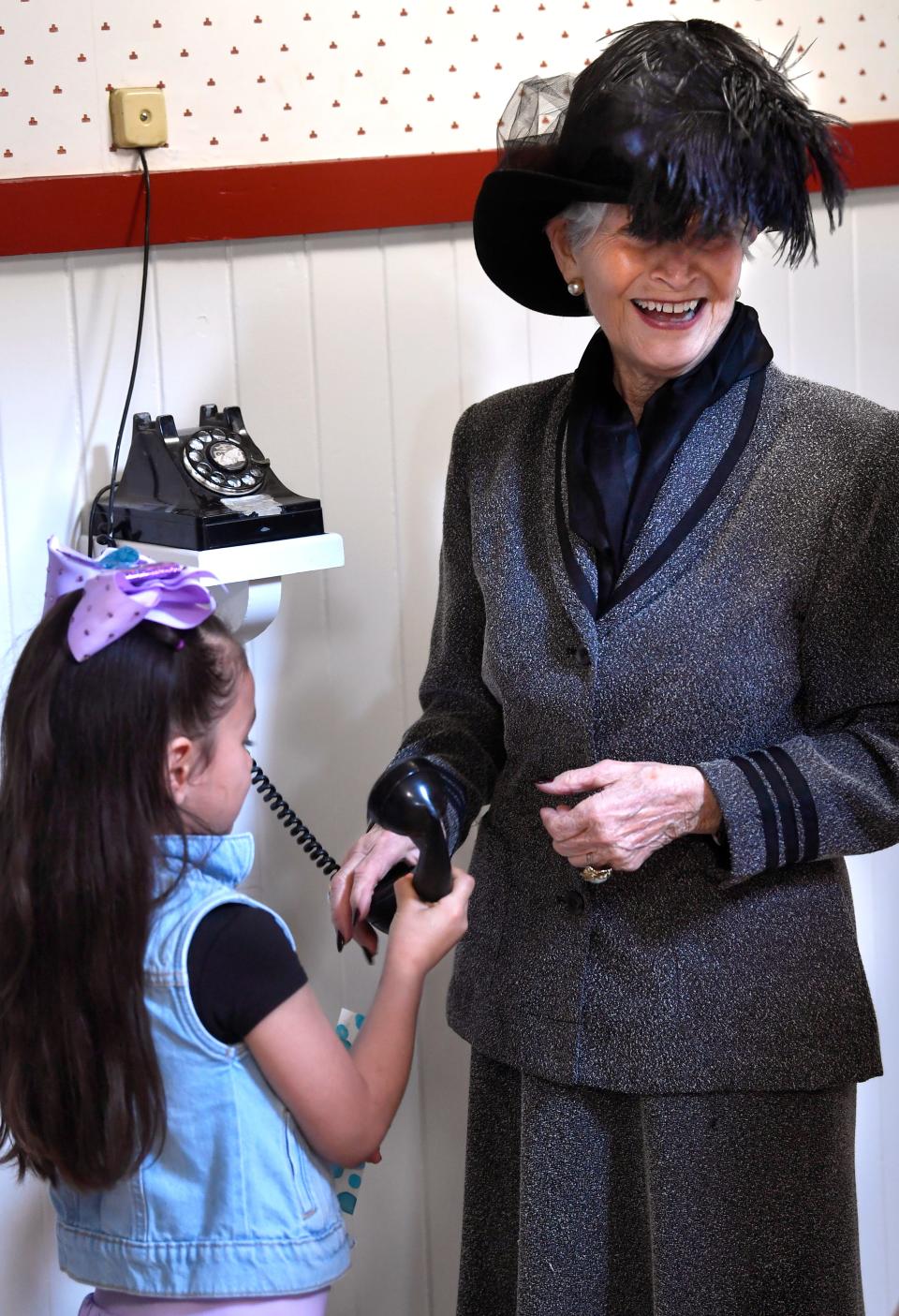 Janet Payne, a house manager for the Swenson House, shows children an early telephone of the kind used in the home in the early 20th Century, during a tour March 30.