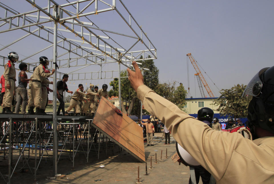 Security personnel remove a shelter where Cambodian National Rescue Party leaders give a speech to their supporters at Democracy Square in Phnom Penh, Cambodia, Saturday, Jan. 4, 2014. Cambodian police have pushed out about 1,000 anti-government demonstrators from a park in the capital Phnom Penh, a day after four people were killed in a crackdown on a labor protest. (AP Photo/Heng Sinith)