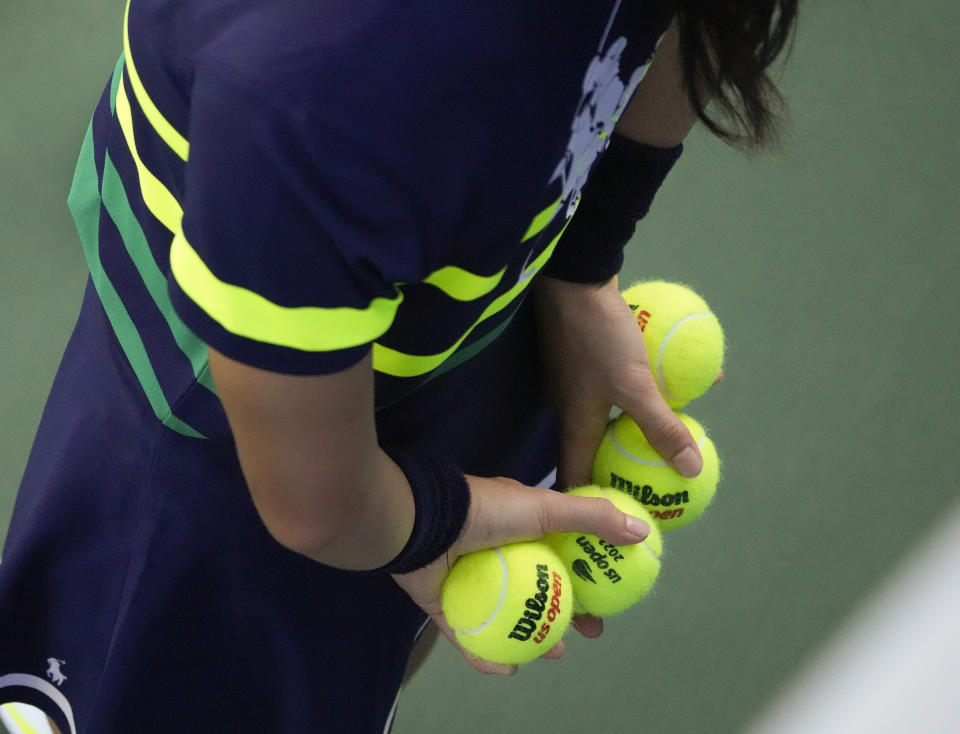 A ball person holds tennis balls ready for service during the second round of the U.S. Open tennis championships, Thursday, Aug. 31, 2023, in New York. Grand Slam events will go through more than 100,000 balls over the course of the tournament. (AP Photo/Mary Altaffer)