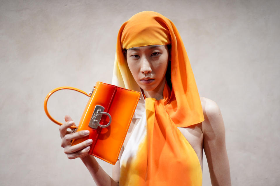 A model poses for a photographer backstage before the Ferragamo women's Spring Summer 2023 collection presented in Milan, Italy, Saturday, Sept. 24, 2022. (AP Photo/Alberto Pezzali)