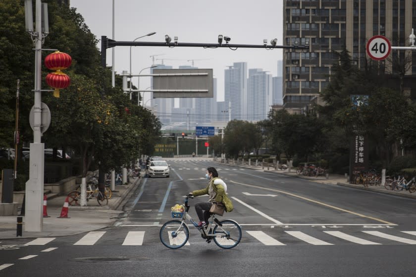 WUHAN, CHINA - FEBRUARY 11: A women wears a protective mask as she rides a bicycle on February 11.2020 in Wuhan. Hubei province,China. Flights, trains and public transport including buses, subway and ferry services have been closed for the twentieth days. The number of those who have died from the Wuhan coronavirus, known as 2019-nCoV, in China climbed to 1017. (Photo by Getty Images)