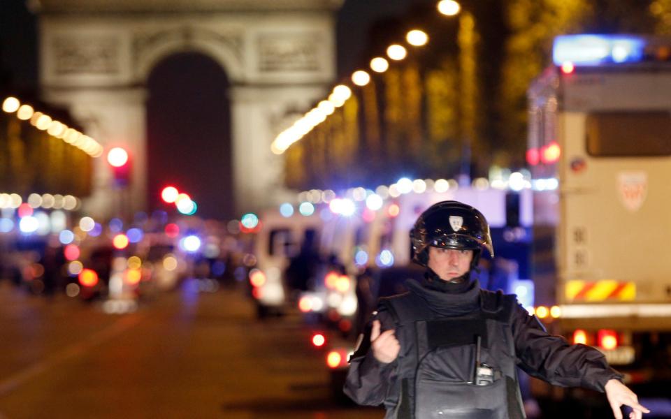 A police officer stands guard after the fatal shooting - Credit: AP