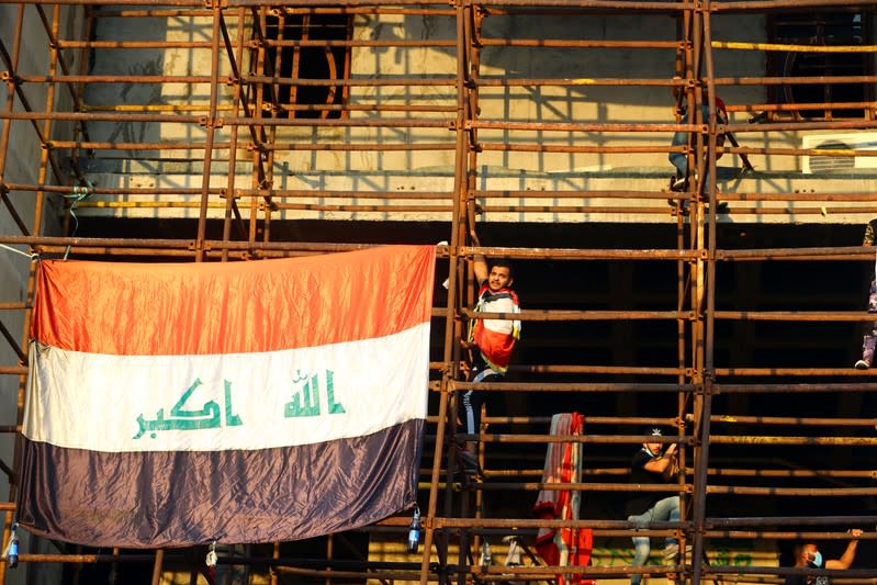 Iraqi demonstrators climb the high-rise building, called by Iraqi the Turkish Restaurant Building, during anti-government protests in Baghdad