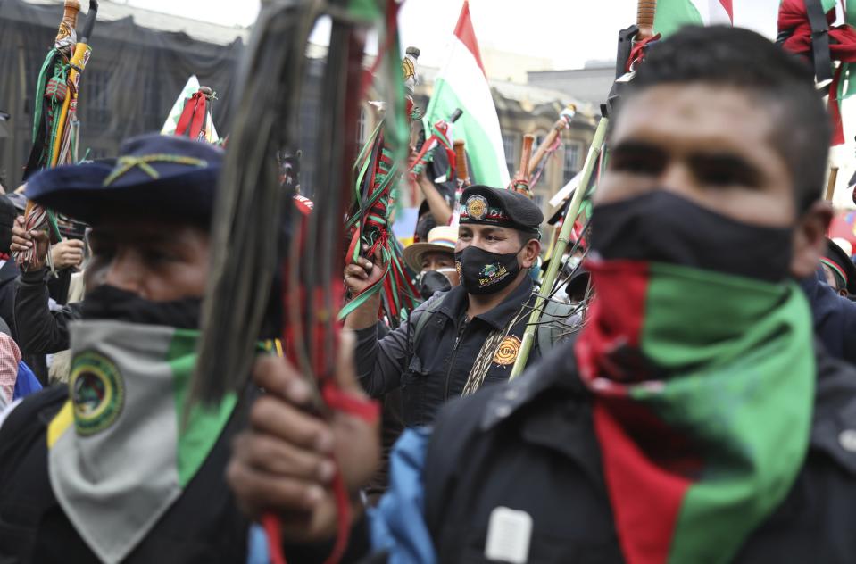 Members of the Indigenous Guard shout slogans against the government during a national strike in Bogota, Colombia, Wednesday, Oct. 21, 2020. Workers' unions, university students, human rights defenders, and Indigenous communities have gathered for a day of protest in conjunction with a national strike across Colombia. The protest is against the assassinations of social leaders, in defense of the right to protest and to demand advances in health, income and employment. (AP Photo/Fernando Vergara)