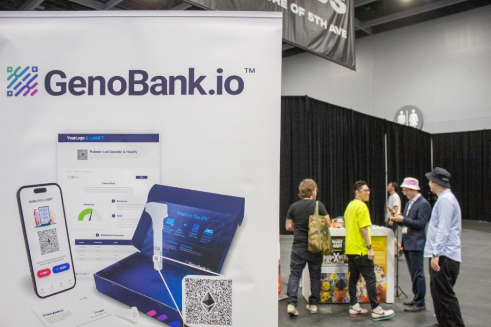 The GenoBank.io sign juxtaposed with a group of people behind it.