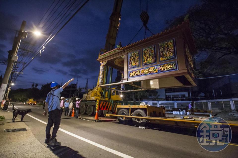 工程人員將吊車掛勾掛上廟宇屋頂，一座9坪大的土地公廟瞬間騰空而起，緩緩穿過2棵樹中間，不偏不倚地落在風水師指定的基座上。