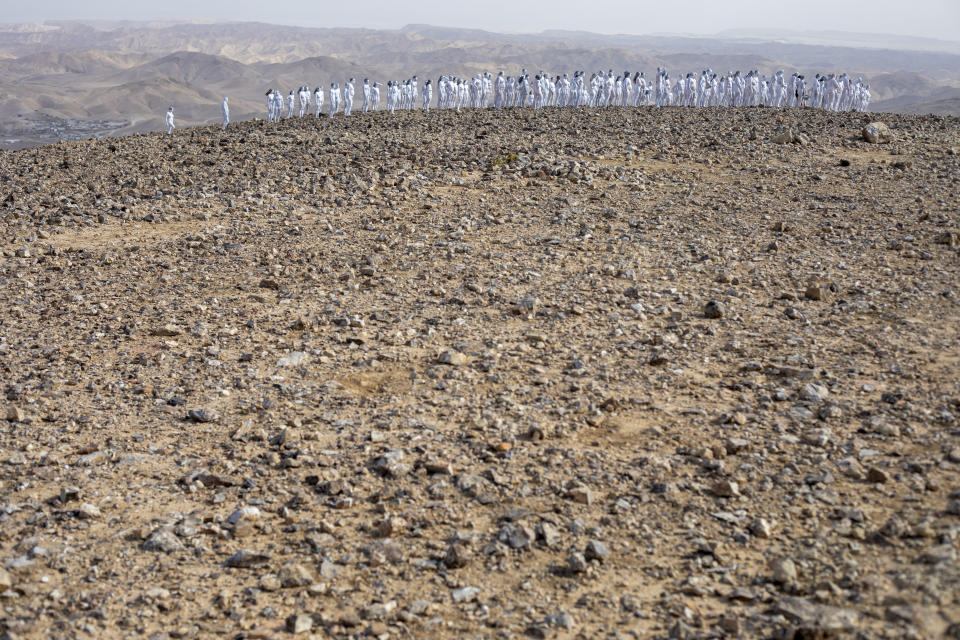 People pose nude for American artist Spencer Tunick as part of an installation in the desert near the Dead Sea, in Arad, Israel, Sunday, Oct. 17, 2021. About 300 participants took part in the nude photo installation designed to draw world attention to the importance of preserving and restoring the Dead Sea. (AP Photo/Ariel Schalit)