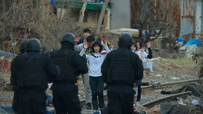 A group of students is confronted by a group of soldiers