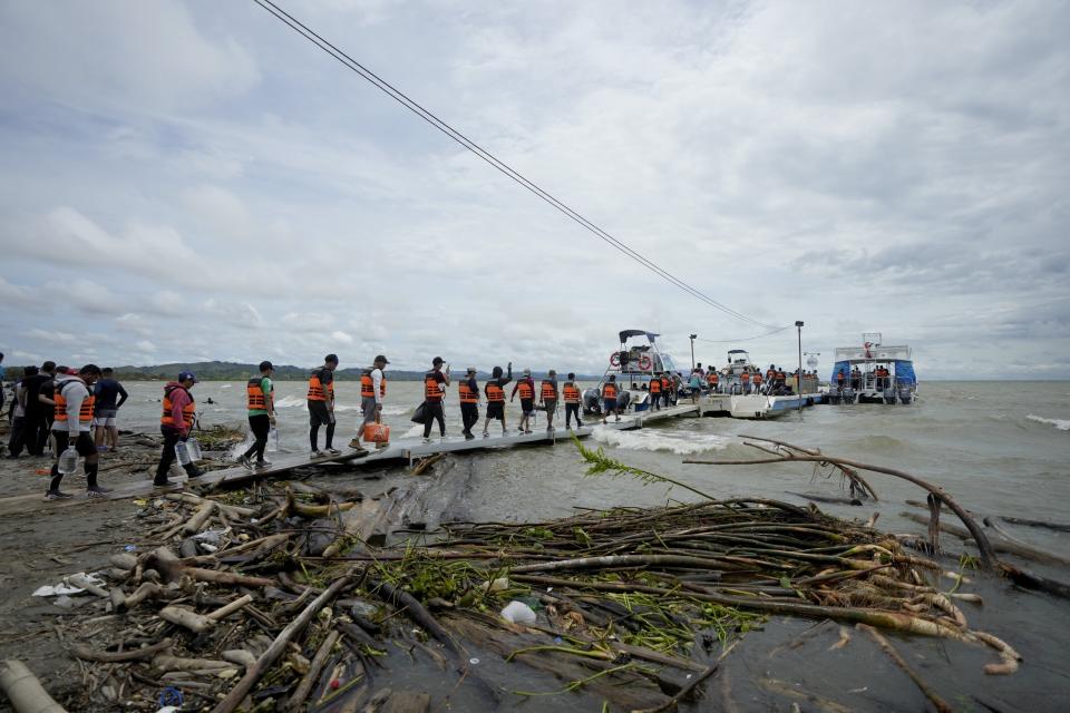 Migrantes venezolanos caminan hacian una lancha que los llevará a Acandi, desde Necocli, Colombia, el 13 de octubre de 2022. Algunos venezolanos están reconsiderando su viaje hacia Estados Unidos luego de que la Casa Blanca anunció el 12 de octubre que los venezolanos que crucen la frontera a pie o a nado serán devueltos de inmediato a México sin derecho a solicitar asilo. (AP Foto/Fernando Vergara)