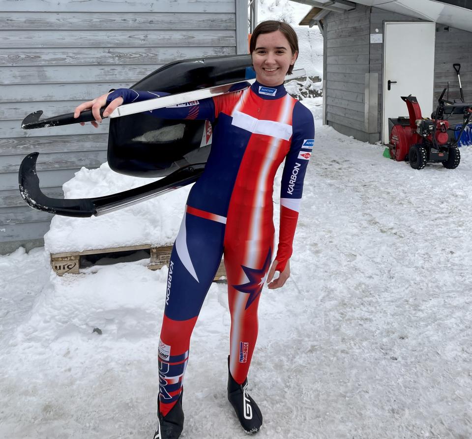 Adeline Albert poses for a photo while carrying her sled.