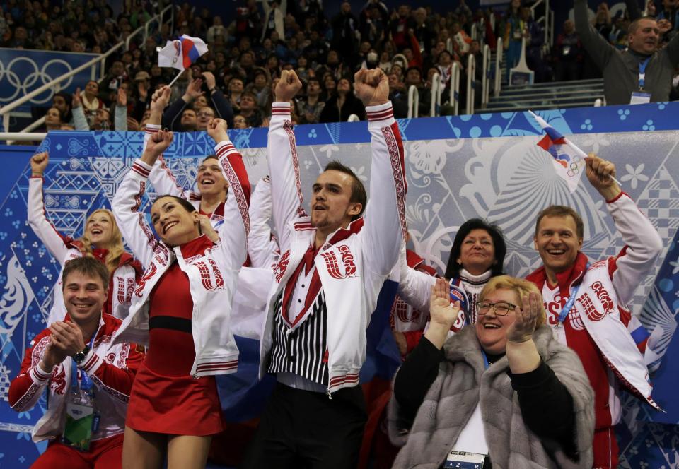 Ksenia Stolbova and Fedor Klimov (C) of Russia react with their teammates in the "kiss and cry" area during the Team Pairs Free Skating Program at the Sochi 2014 Winter Olympics, February 8, 2014. REUTERS/Darron Cummings/Pool (RUSSIA - Tags: SPORT FIGURE SKATING SPORT OLYMPICS)