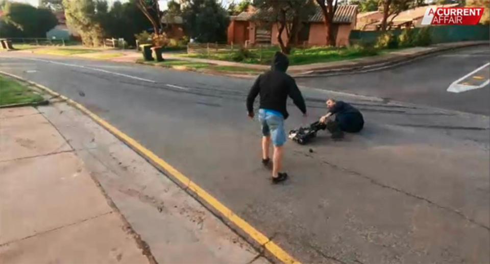 The cameraman lays on the road with a damaged camera, after the altercation with the Adelaide man. Source: A Current Affair