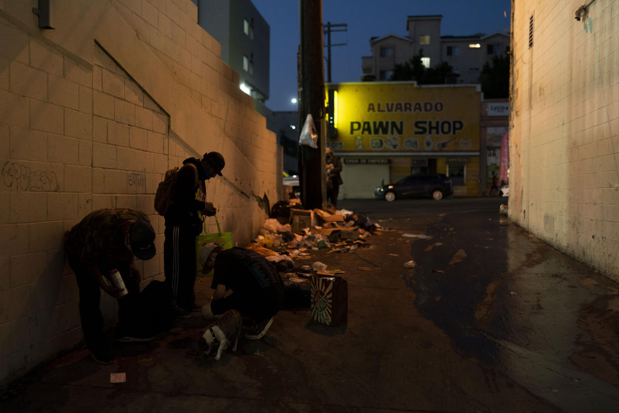 Drug addicts smoke fentanyl next to piles of trash in an alley in Los Angeles, Tuesday, Aug. 23, 2022. For too many people strung out on the drug, the sleep that follows a fentanyl hit is permanent. The highly addictive and potentially lethal drug has become a scourge across America and is taking a toll on the growing number of people living on the streets of Los Angeles. (AP Photo/Jae C. Hong)