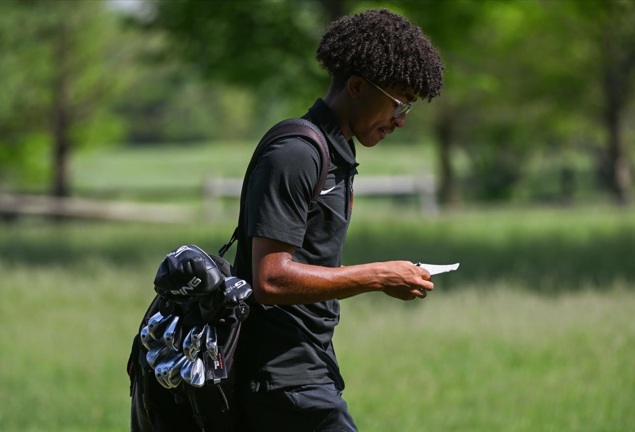 Edgewood’s Carter Cheaney looks at his scorecard during the Bloomington North golf invite at Cascades Golf Course on Saturday, May 4, 2024.