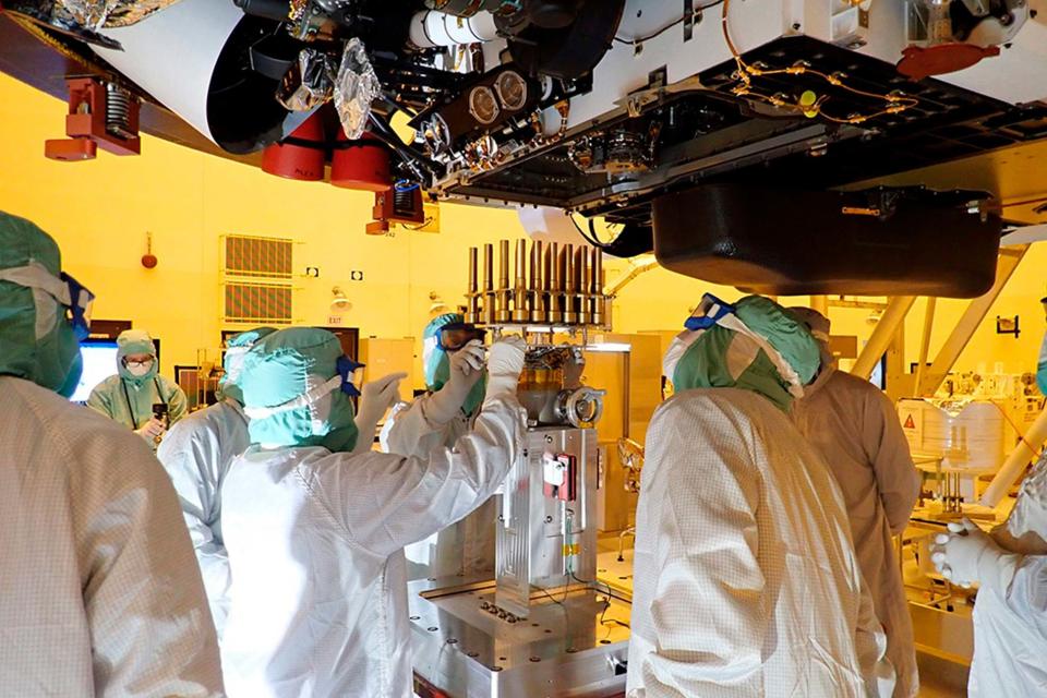 Engineers insert tubes into the Mars rover at the Kennedy Space Centre in Florida (AP)