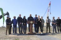 Maryland Gov. Wes Moore speaks at a news conference at Tradepoint Atlantic in Sparrows Point, Md. on Friday, March 29, 2024 with officials gathered to discuss efforts to remove wreckage from the collapse of the Francis Scott Key Bridge Bridge. The Chesapeake 1000 crane is behind the gathering of officials to the right. (AP Photo/Brian Witte)