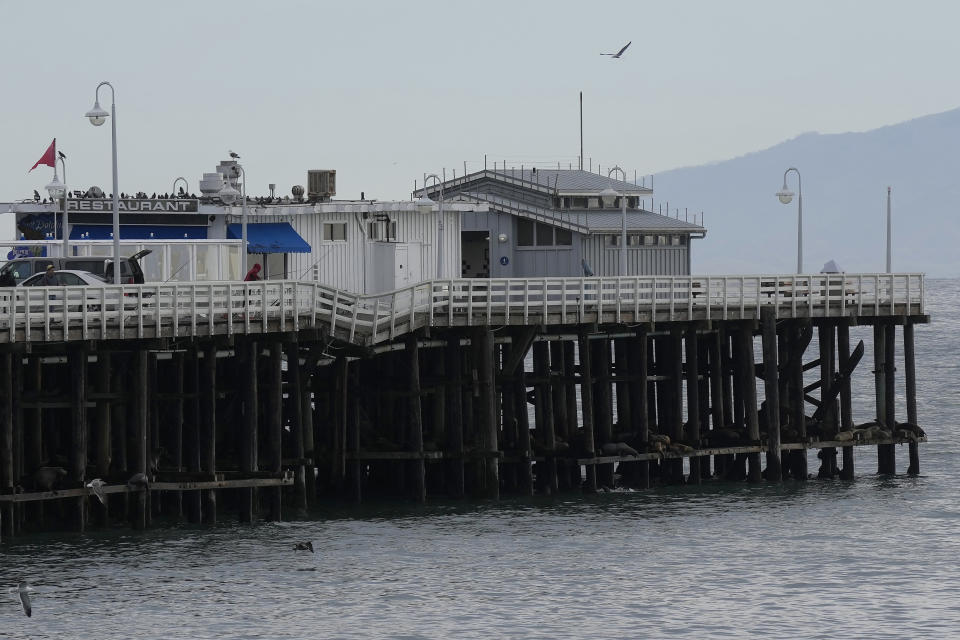 A damaged portion of the Santa Cruz Wharf hangs from the railing in Santa Cruz, Calif., Friday, Jan. 12, 2024. Rising seas, frequent storms take toll on California's iconic piers, threatening beach landmarks.(AP Photo/Jeff Chiu)