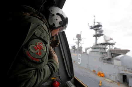 A crewman aboard a U.S. Marine MV-22B Osprey Aircraft looks out as it lifts off the deck of the USS Bonhomme Richard amphibious assault ship off the coast of Sydney, Australia, after a ceremony on board the ship marking the start of Talisman Saber 2017, a biennial joint military exercise between the United States and Australia, June 29, 2017. REUTERS/Jason Reed