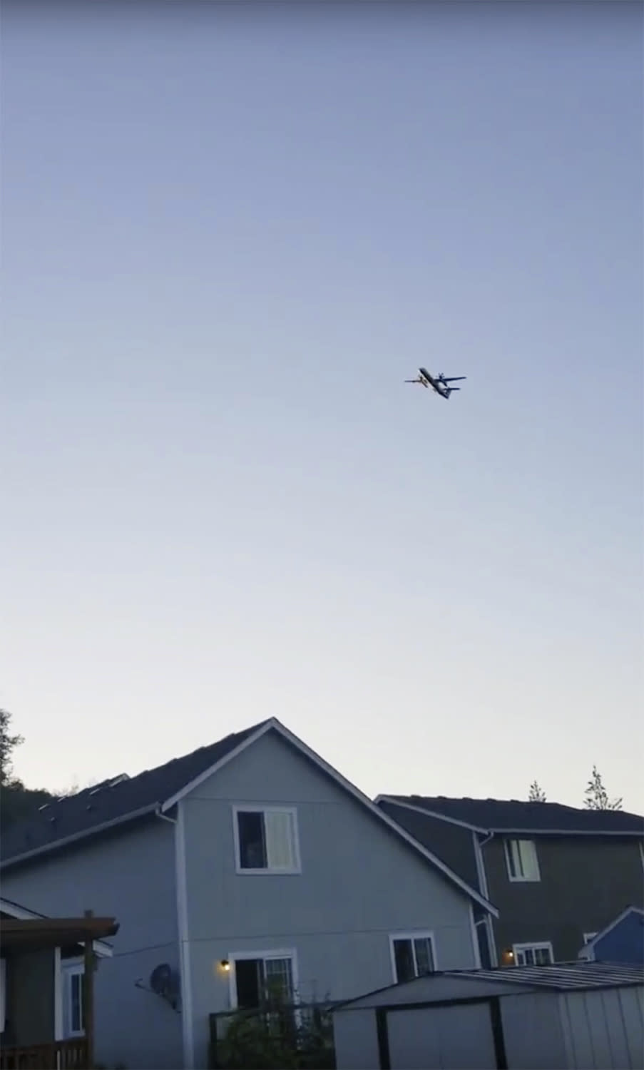 This photo taken from video provided by Courtney Junka shows the stolen Horizon Air turboprop plane flying over Eatonville, Wash., Friday, Aug. 10, 2018. Officials say an airline employee stole an empty Horizon Air turboprop plane with no passengers aboard, and took off from Sea-Tac International Airport in Washington state on Friday night before crashing into a small island. The Pierce County Sheriff's Department says preliminary information suggests the crash occurred because the 29-year-old man was "doing stunts in air or lack of flying skills." (Courtney Junka via AP)