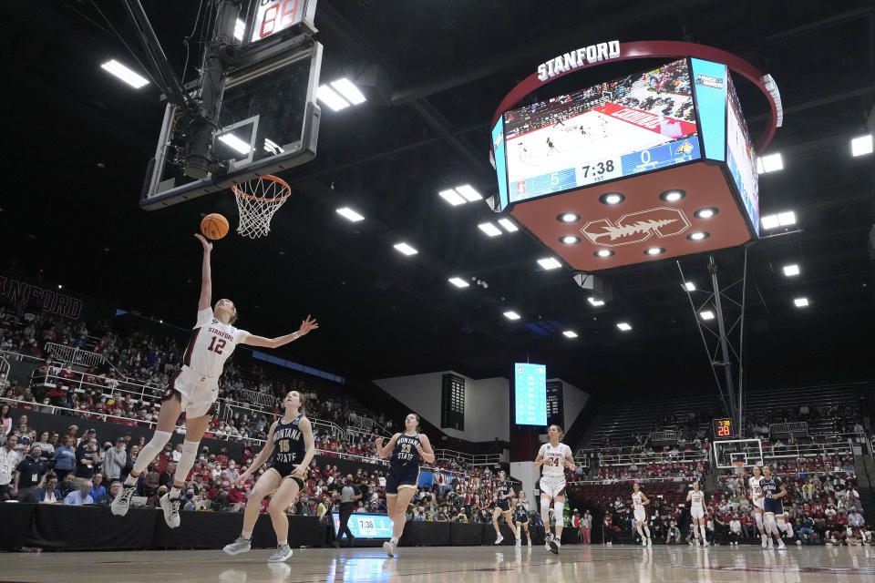 Stanford guard Lexie Hull (12) drives to the basket past Montana State guard Leia Beattie (15) during the first half of a first-round game in the NCAA women's college basketball tournament Friday, March 18, 2022, in Stanford, Calif. (AP Photo/Tony Avelar)