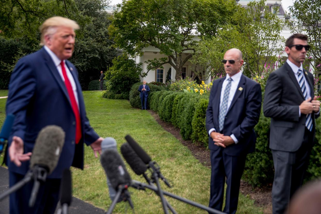 Members of the Secret Service stand outside the Oval Office as President Donald Trump, left, speaks to reporters on the South Lawn of the White House in Washington, Monday, Sept. 9, 2019. 