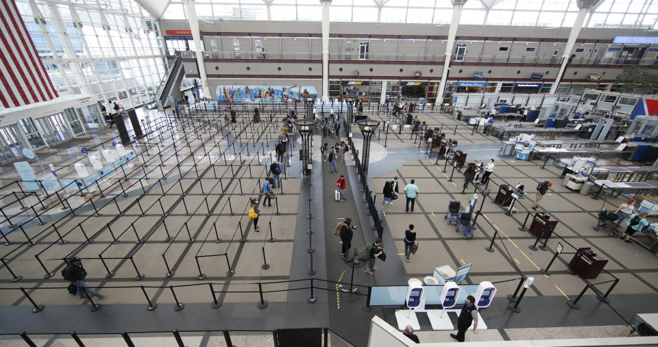 Few travelers queue up to pass through the south security checkpoint in the main terminal at Denver International Airport Thursday, April 23, 2020, in Denver. (AP Photo/David Zalubowski)