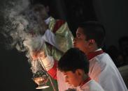 An altar boy holds a censer with burning incense during Christmas mass at a church in Ajmer district in the desert Indian state of Rajasthan December 25, 2013. REUTERS/Stringer (INDIA - Tags: RELIGION SOCIETY)