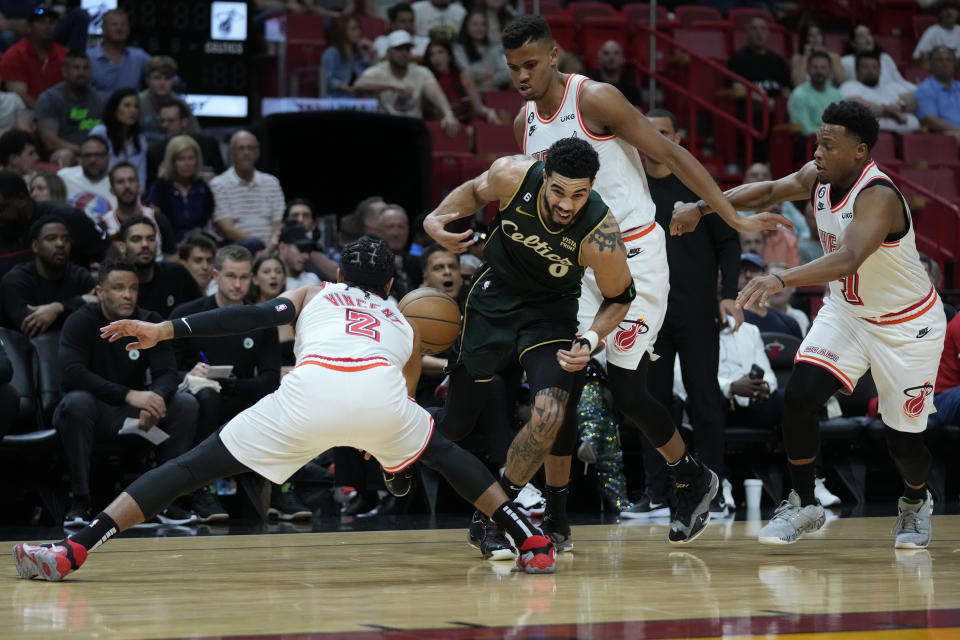 Boston Celtics forward Jayson Tatum (0) loses control of the ball against Miami Heat guard Gabe Vincent (2) center Orlando Robinson and guard Kyle Lowry (7) during the first half of an NBA basketball game, Tuesday, Jan. 24, 2023, in Miami. (AP Photo/Wilfredo Lee)