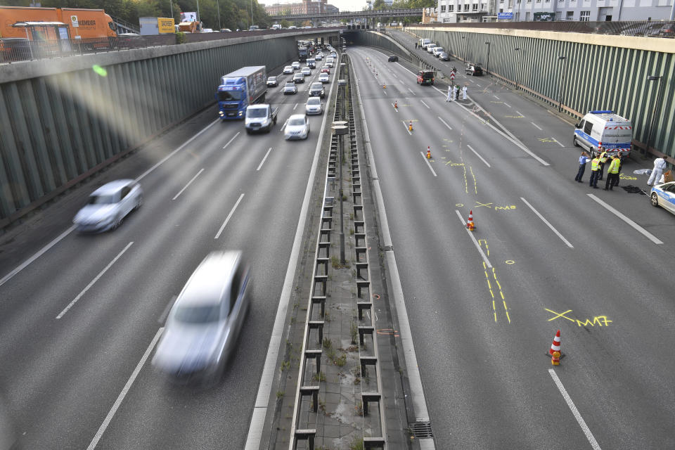 Police officers investigate on the scene following several accidents on the city motorway A100 in Berlin, Germany, Wednesday, Aug. 19, 2020. According to German news agency dpa, prosecutors say a series of crashes caused by a 30-year-old Iraqi man on the highway late Tuesday night was an Islamic extremist attack. (Paul Zinken/dpa via AP)