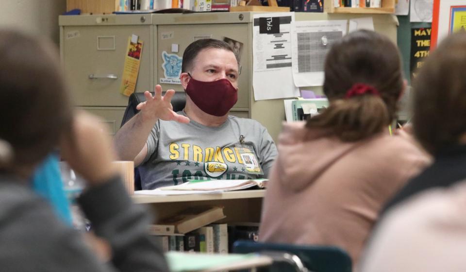 With students learning in his classroom and remotely on his computer screen, teacher David Finkle often feels stuck in a corner where the camera on his laptop can see him, repeating questions from one set of students so the others can hear them.