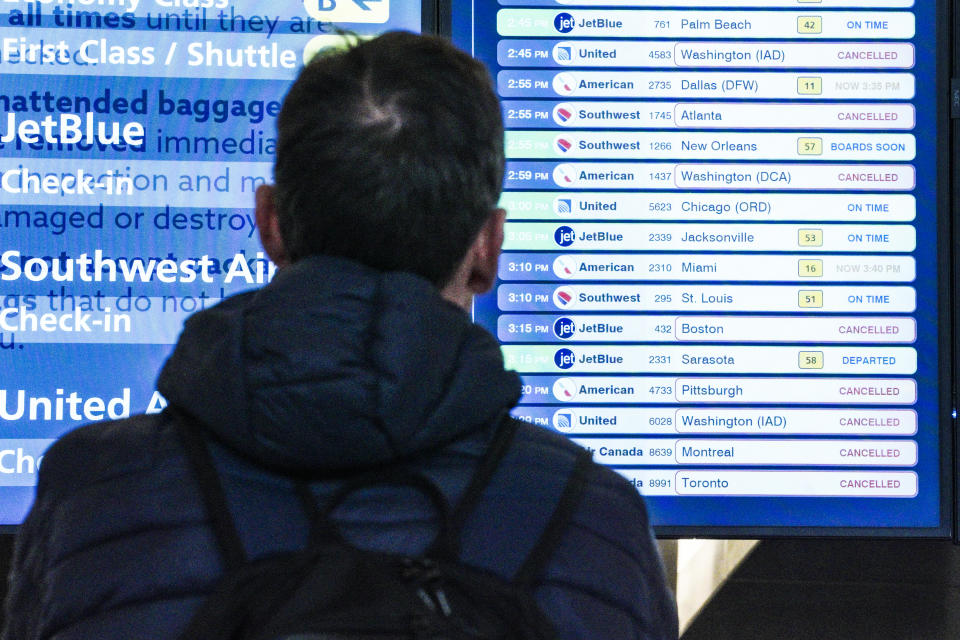 A passenger checks flight departures showing cancellations at Laguardia Airport, Friday Dec. 23, 2022, in New York. (AP Photo/Bebeto Matthews)