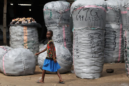 A girl walks past bags of shoes packed for transportation to Cameroon at Ariaria market in Aba, Nigeria August 19, 2016. REUTERS/Afolabi Sotunde