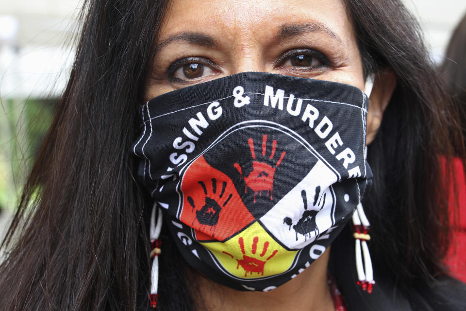 FILE - In this Wednesday, Aug. 26, 2020, file photo, Jeannie Hovland, the deputy assistant secretary for Native American Affairs for the U.S. Department of Health and Human Services, poses with a Missing and Murdered Indigenous Women mask, in Anchorage, Alaska, while attending the opening of a Lady Justice Task Force cold case office in Anchorage, which will investigate missing and murdered Indigenous women. From the nation’s capitol to Indigenous communities across the American Southwest, top government officials, family members and advocates are gathering Wednesday, May 5, 2021, as part of a call to action to address the ongoing problem of violence against Indigenous women and children. (AP Photo/Mark Thiessen, File)