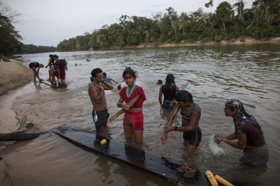 In this Sept. 3, 2019 photo, members of the Tembé indigenous tribe bathe at the the Gurupi river in the Tekohaw indigenous reserve, Para state, Brazil. The members of nine indigenous Tembé tribes of Brazil met to discuss a forest management plan by an association that included technology to curb loggers illegally encroaching on indigenous Tembé land in exchange for the creation of a ring to extract wood, bananas and the oily purple berry of the açaí palm tree that is a staple of native Amazon cuisine and a global superfood. (AP Photo/Rodrigo Abd)