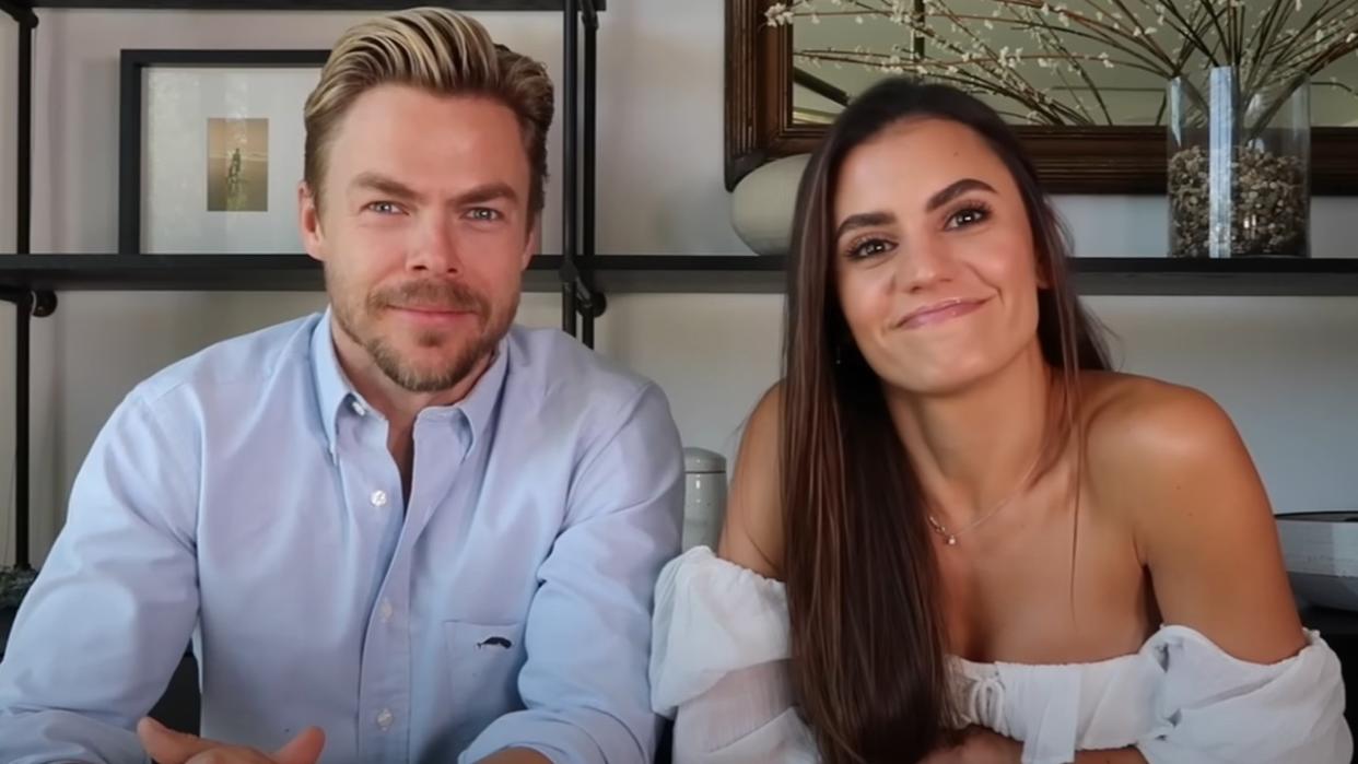  A screenshot of Derek Hough and Hayley Erbert smiling into the camera on their YouTube channel. 