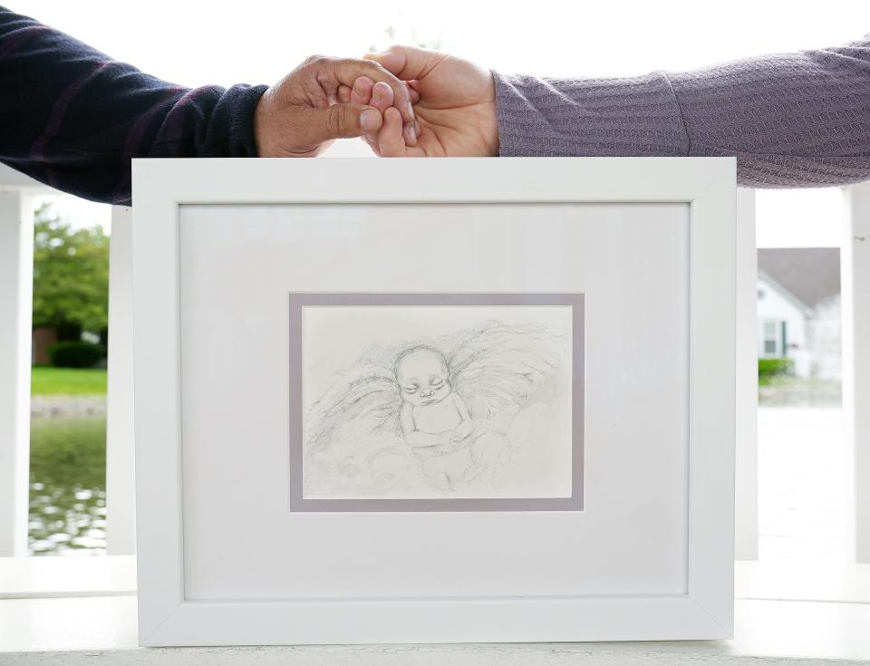 Meg Piasecki and her partner, Ricardo Jimenez, holding hands, traveled to Colorado for an abortion in 2018 after learning the fetus had a chromosomal abnormality. Today they have a sketch of that daughter, whom they named Praisley.