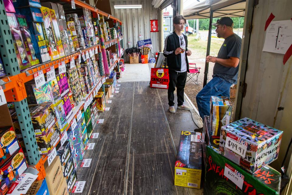 Jacob Enloe buys fireworks from Lucas Allsup at the Iowa Fireworks Company in Clive, Thursday, June 24, 2021. On July 3, 2021, an Iowa Fireworks Company fireworks stand in Clive suffered $10,000 in damages from a fire in a fireworks storage container.