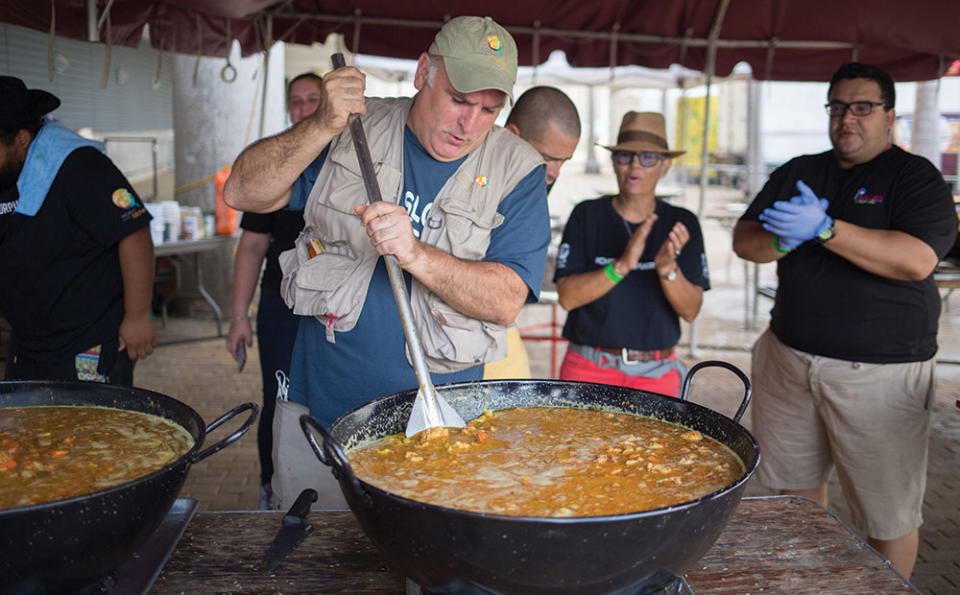Jose Andres (front left) stirs a pot of food in San Juan, Puerto Rico in We Feed People.