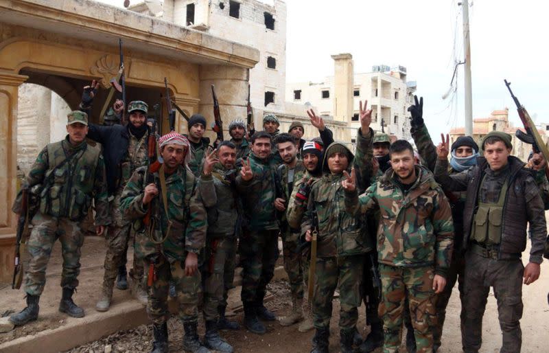 Syrian army soldiers gesture in al-Rashideen area in Aleppo province