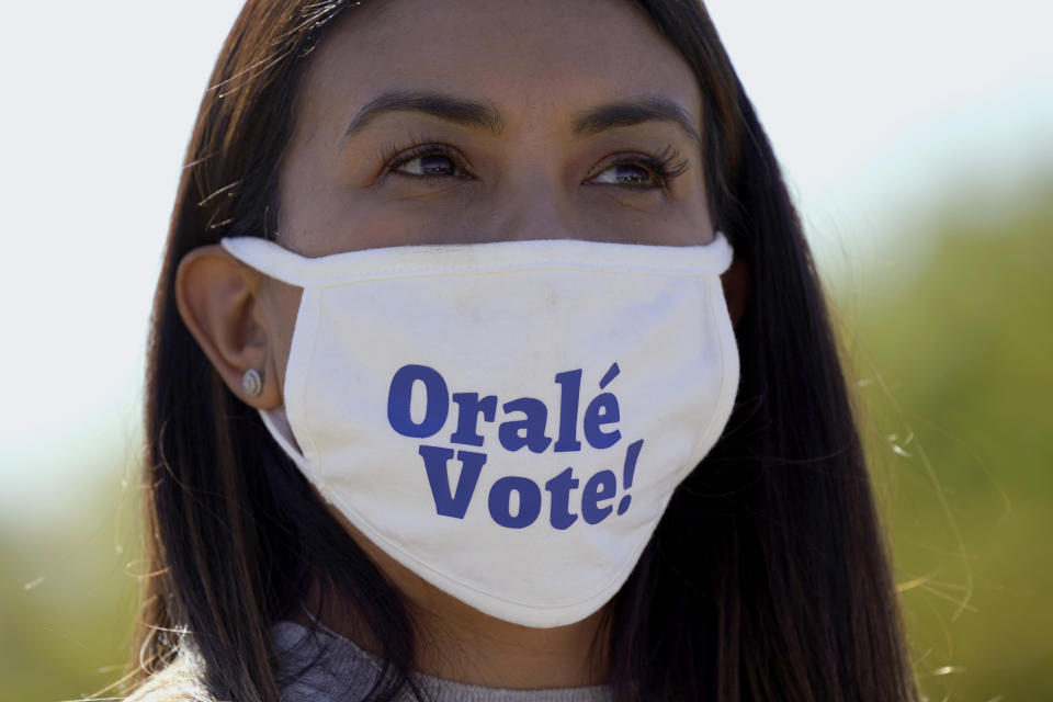Una latina que apoya la fórmula presidencial demócrata de Joe Biden y Kamala Harris promueve el voto en Fort Worth, Texas, en octubre de 2020. (AP Photo/LM Otero)
