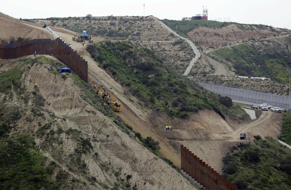 FILE - In this March 11, 2019, file photo, construction crews replace a section of the primary wall separating San Diego, above right, and Tijuana, Mexico, below left, seen from Tijuana, Mexico. The Biden administration says it will begin work to address flooding and soil erosion risks from the unfinished wall on the U.S. border with Mexico. It also began providing answers on how it will use unspent money from shutting down one of President Donald Trump's signature domestic projects. The Defense Department says it will use unobligated money for military construction projects for its initial purpose. The repair work will take place in Texas' Rio Grande Valley and San Diego. (AP Photo/Gregory Bull, File)