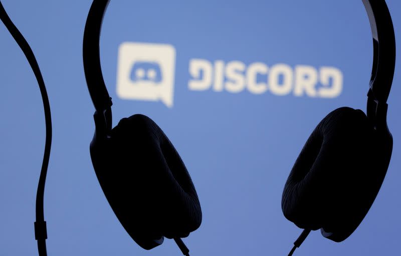 Headphones are seen in front of displayed Discord app logo in this illustration photo