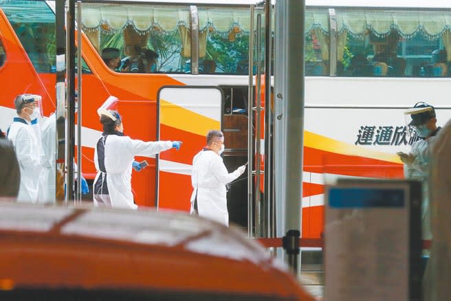 華航機組人員檢疫居住的諾富特華航桃機飯店主管確診新冠肺炎，目前在加護病房治療，29日飯店開始清空作業，共撤離412人至集中檢疫所。工作人員全副武裝穿上防護衣帽，安排住客搭乘遊覽車到集中檢疫所。（陳麒全攝）