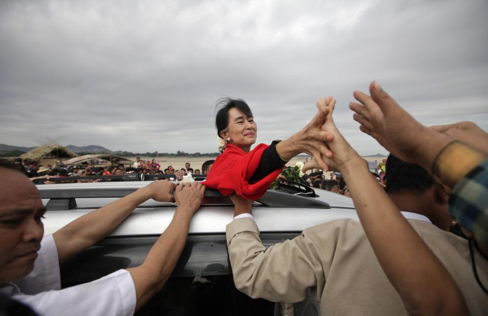 Myanmar's pro-democracy leader Aung San Suu Kyi shakes hands with supporters after giving a speech in Monywa in this November 30, 2012 file photo. Myanmar's president Thein Sein has given his backing on January 2, 2014 for amending a military drafted constitution and indicated support for changes that would make Nobel Peace Prize winner Aung San Suu Kyi eligible to lead the country. REUTERS/Soe Zeya Tun/Files (MYANMAR - Tags: POLITICS ELECTIONS)