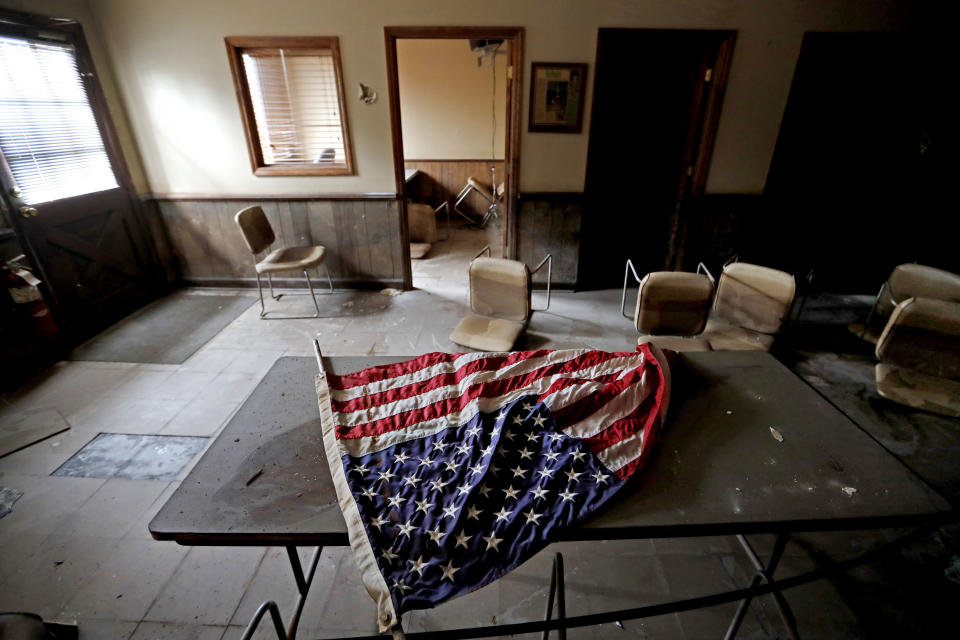 An American flag lays on a table in the old town hall which sits damaged from Hurricane Matthew's flooding two years ago in Nichols, S.C., Thursday, Sept. 13, 2018. The residents of this tiny inland town who rebuilt after Matthew destroyed 90 percent of the homes are uneasy as forecasters warn inland flooding from Hurricane Florence's rain could be one of the most dangerous and devastating parts of the storm. (AP Photo/David Goldman)