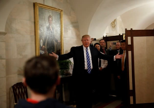 Under a painting of Hillary Clinton, U.S. President Donald Trump makes a surprise appearance to people touring the White House. Kevin Lamarque / Reuters